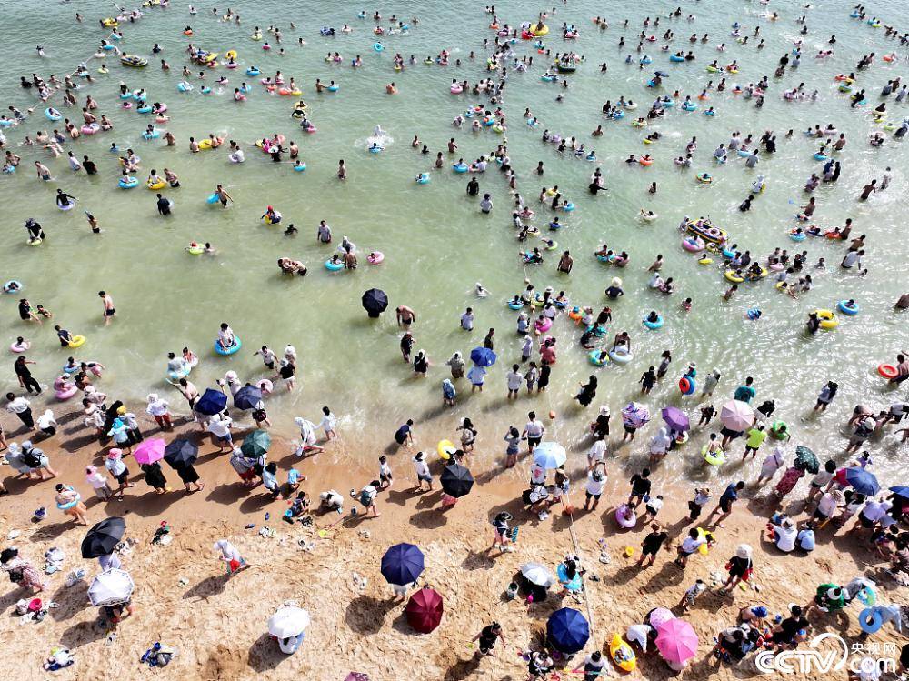 连云港:大沙湾海滨浴场火爆 游客扎堆下饺子