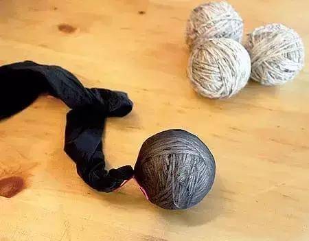 下面,找一只旧丝袜来,把毛线团都放进去,然后用身子挨个固定好,别让