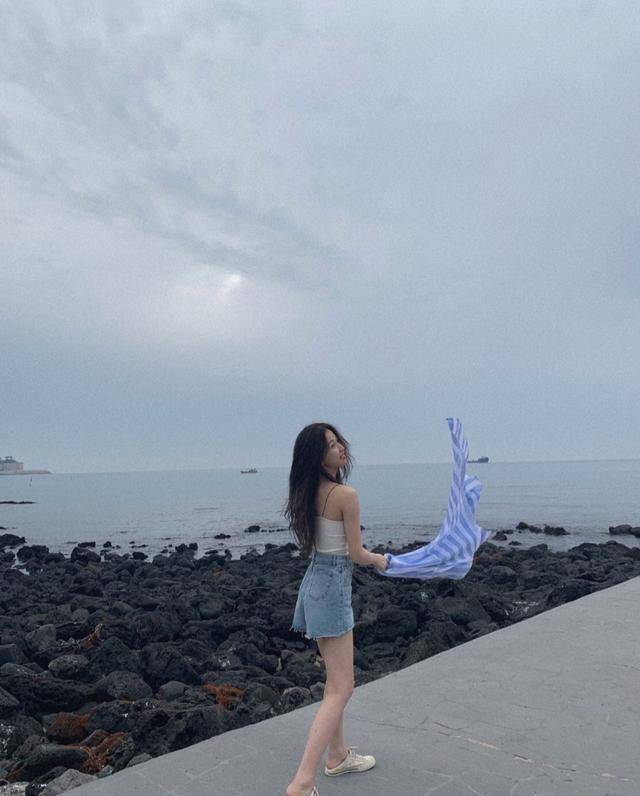 虞书欣在海边的水泥地上,身穿性感的小吊带背心衫,很好展现平滑的背部