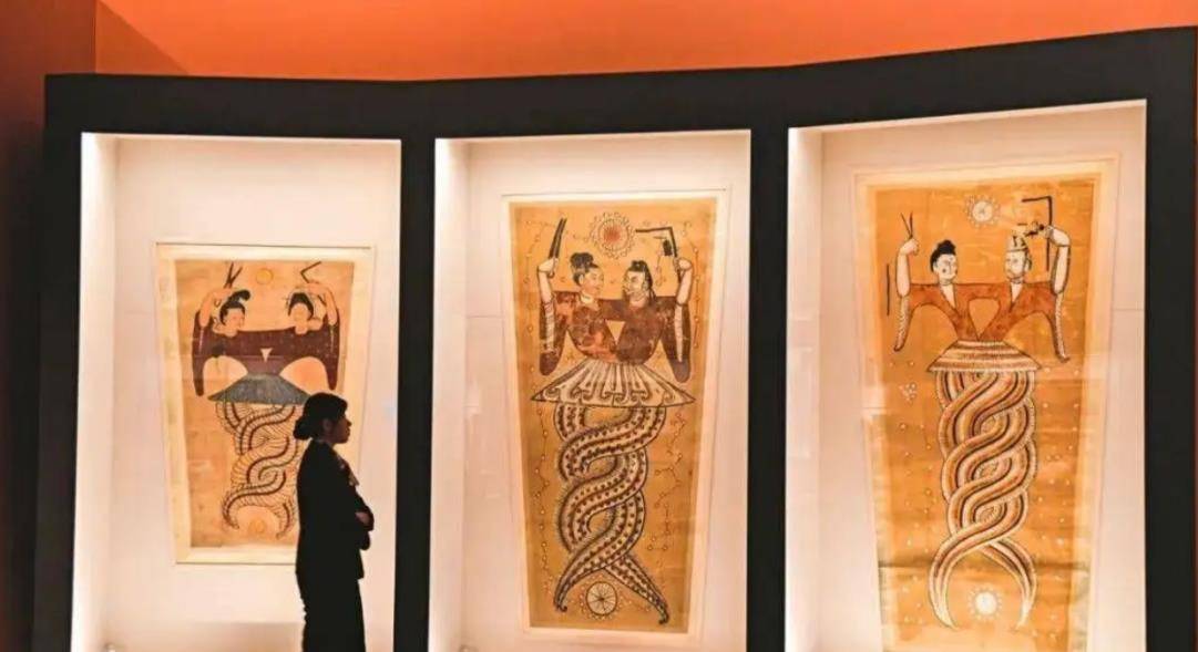 绢图中男女二人上半身是人形,下半身则是呈蛇尾互相缠绕.