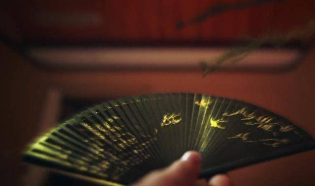 白金的扇子最为特别,黑色扇面,上面还画有鸟.