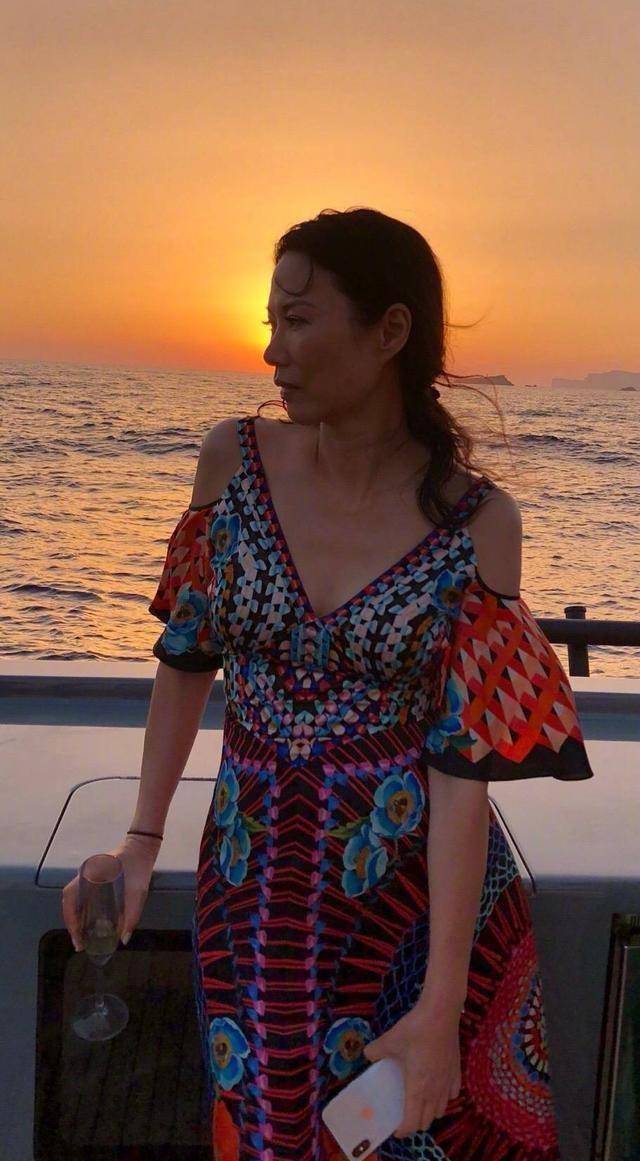 原创51岁邓文迪坐游轮荡秋千,穿马甲笑得像个孩子,完美展现富婆生活