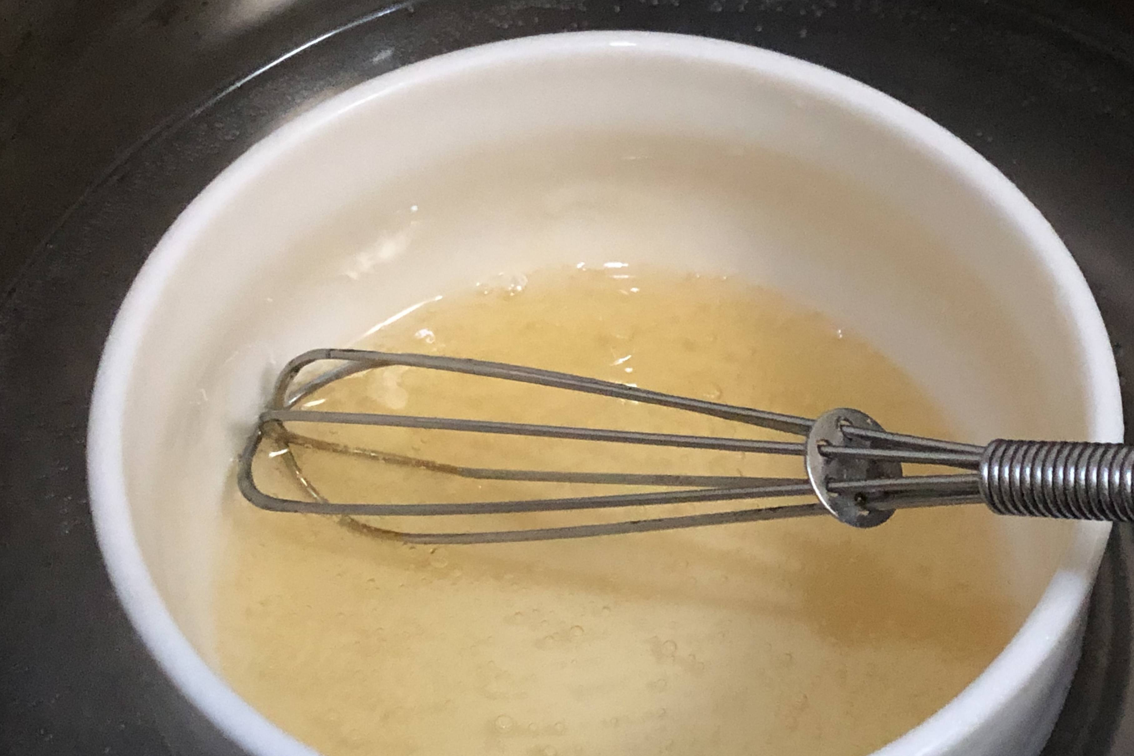 8,接下来,把吉利丁溶液和刚才的芒果糊放到一起,用手动打蛋器搅拌均匀