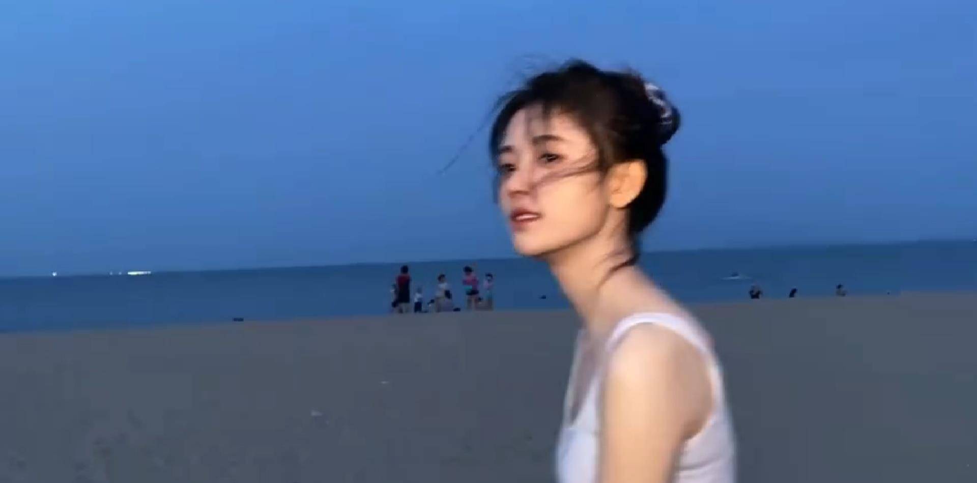 原创鞠婧祎穿白色背心海边漫步头发凌乱似韩系女主镜头下的直角肩堪称