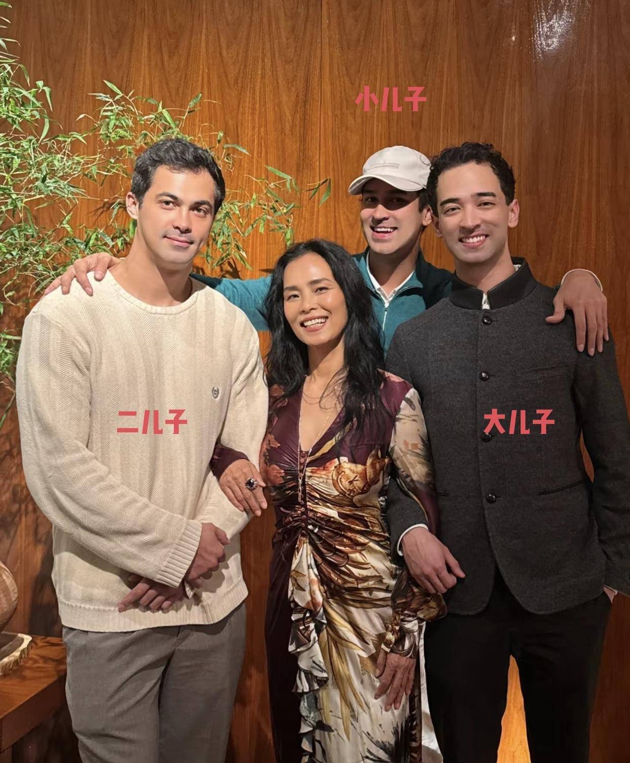 大儿子韦紫明穿着深灰色中式立领外套贴近母亲站立
