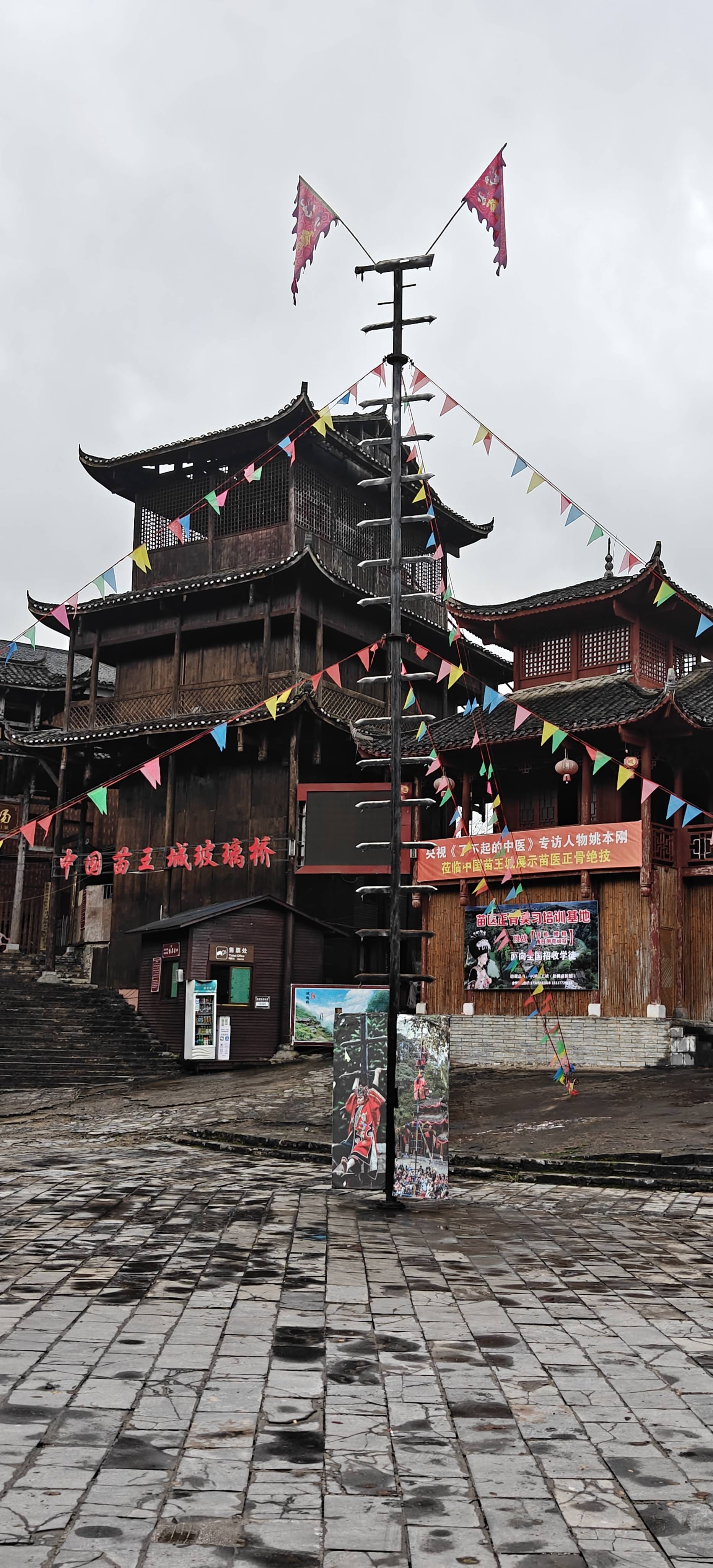 古道两旁,是错落有致的苗族民居,青瓦木墙,飞檐翘角,与周围的自然环境