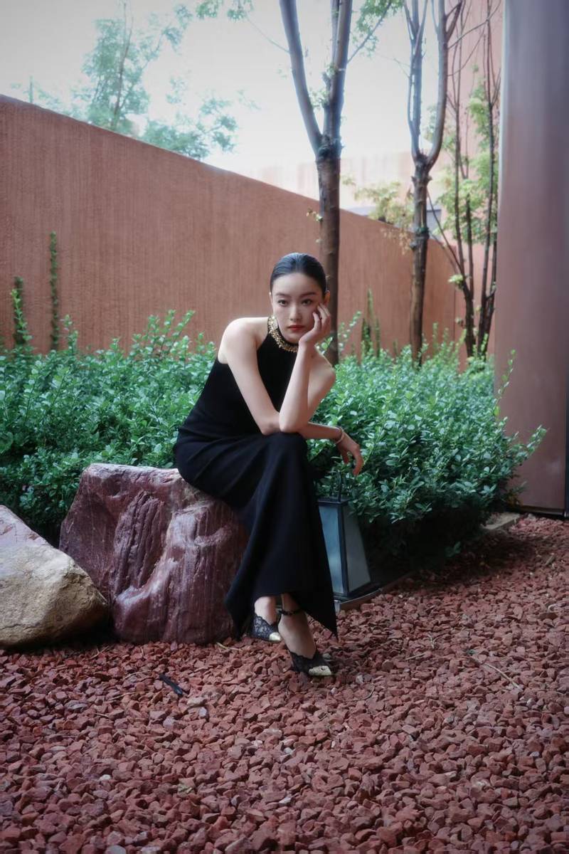 倪妮穿挂脖裙身材曼妙 撑黑伞漫步雨中尽显故事感