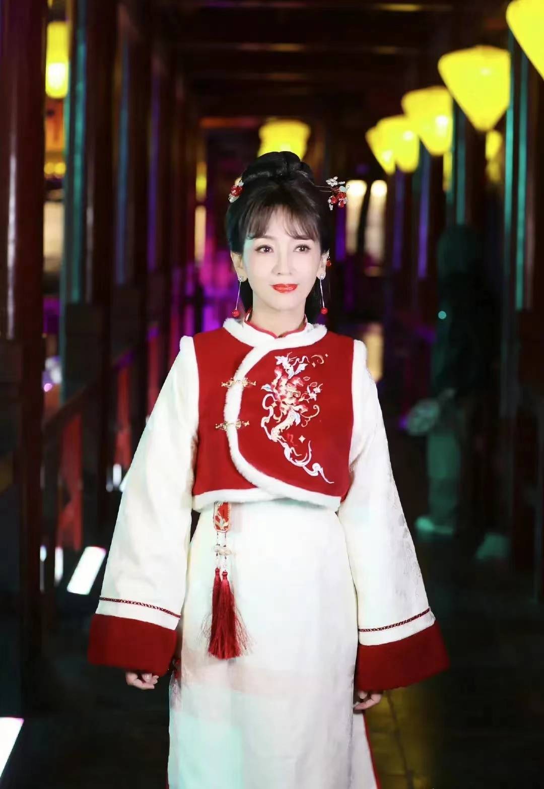 照片中的赵雅芝,身着红色中国风马甲和白色旗袍,不仅展现了浓厚的