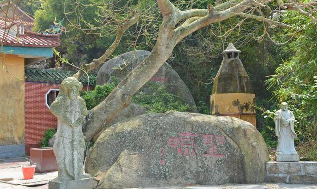 井边岩石上刻着"圣凉"二字,立着一尊持剑的武将守护着.