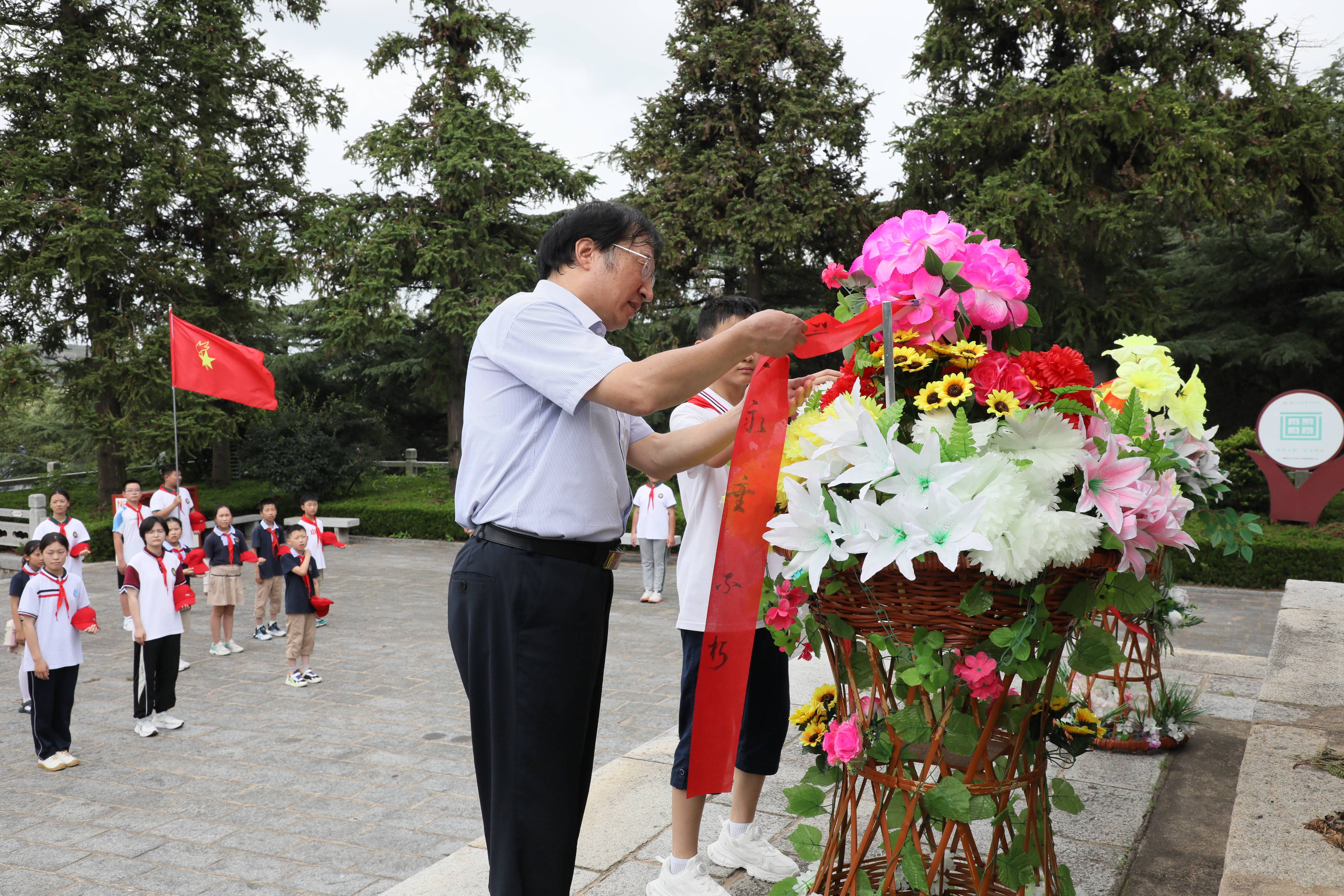 传承红色基因"的倡议,并向烈士敬献花篮,赣榆区关工委主任王学济牵着