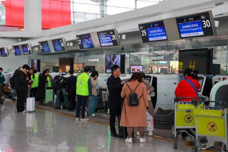 白雲機場航站樓內,旅客有序辦理自助值機行李託運業務.