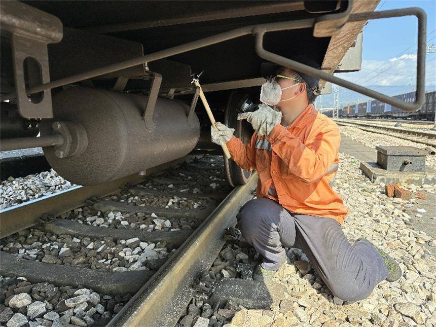 覃泽诚摄工作人员在检查车辆缓解阀拉杆吊架.覃泽诚摄