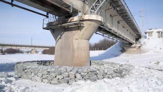 们快速把碎冰用锹转移,然后把2米见方的一张张铁丝网连起来放进凹槽内