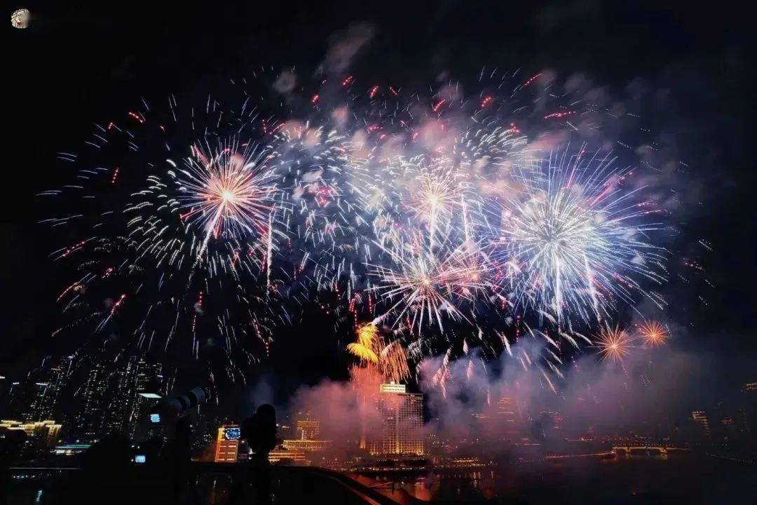 英雄花开英雄城,烟花腾空,在高空中打出红绿交辉的红棉图案.