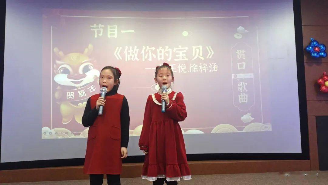 徐梓涵和杭王悦两位同学身着红色连衣裙,头戴红色蝴蝶结,精神抖擞地