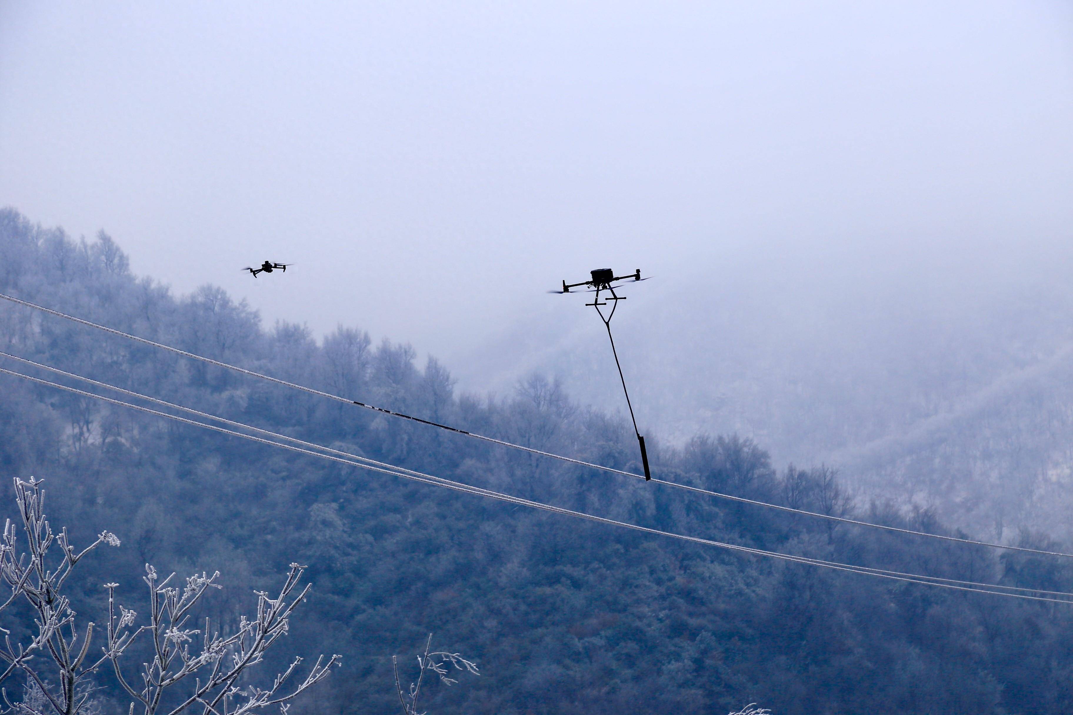 河南首次利用无人机开展配网线路不停电除冰作业在新县完成_供电_电力