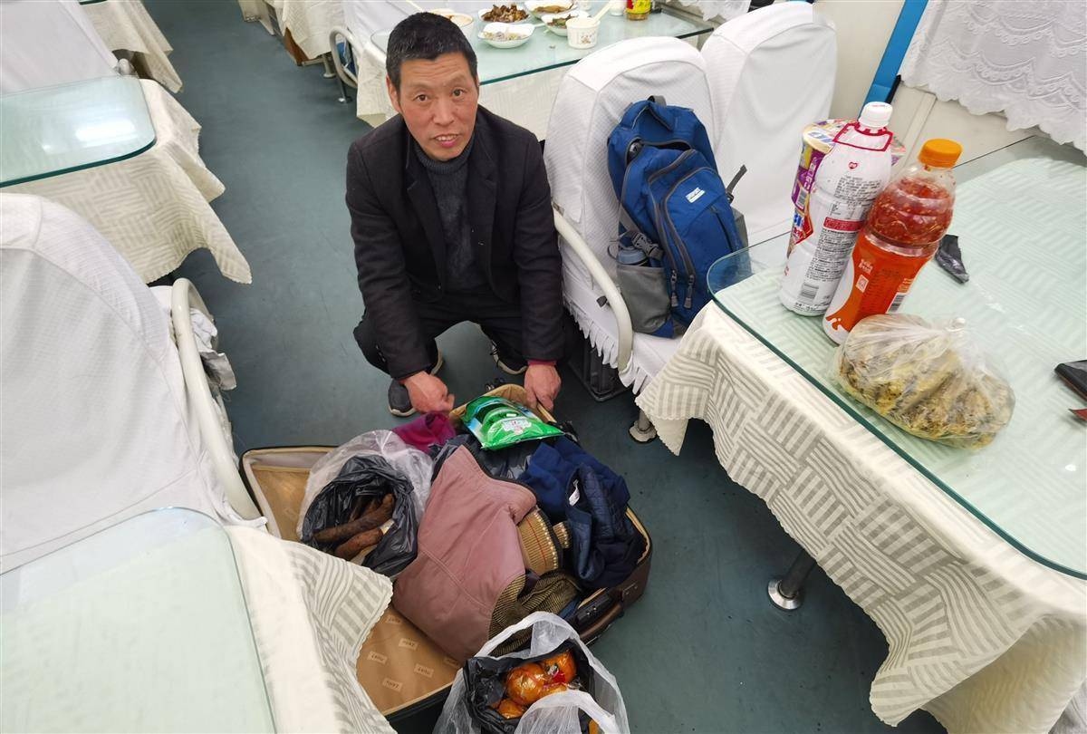 k4505返岗专列上,徐红忠展示他的行囊.