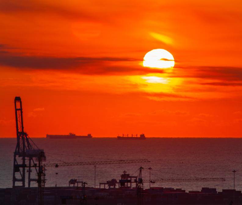 苍穹下当红橙色的霞光与幽蓝的天空交融,绚烂的光芒铺就,朵朵流云被