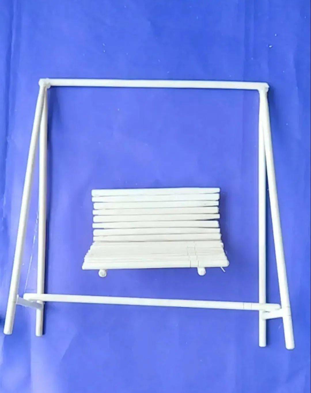 其余筷子剪成同样长度的小木棍,用热熔胶粘成椅子,用绳子连接椅子与