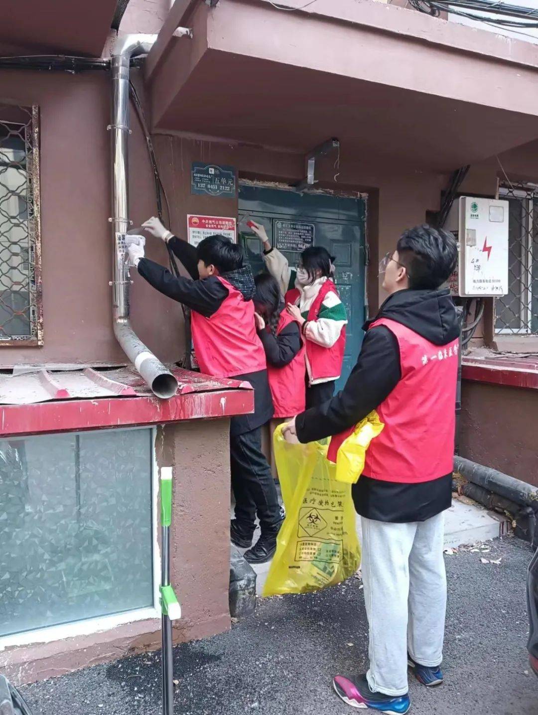 还有一路拿着小铲子和酒精喷雾以及垃圾袋清理小区楼道的小广告,他们