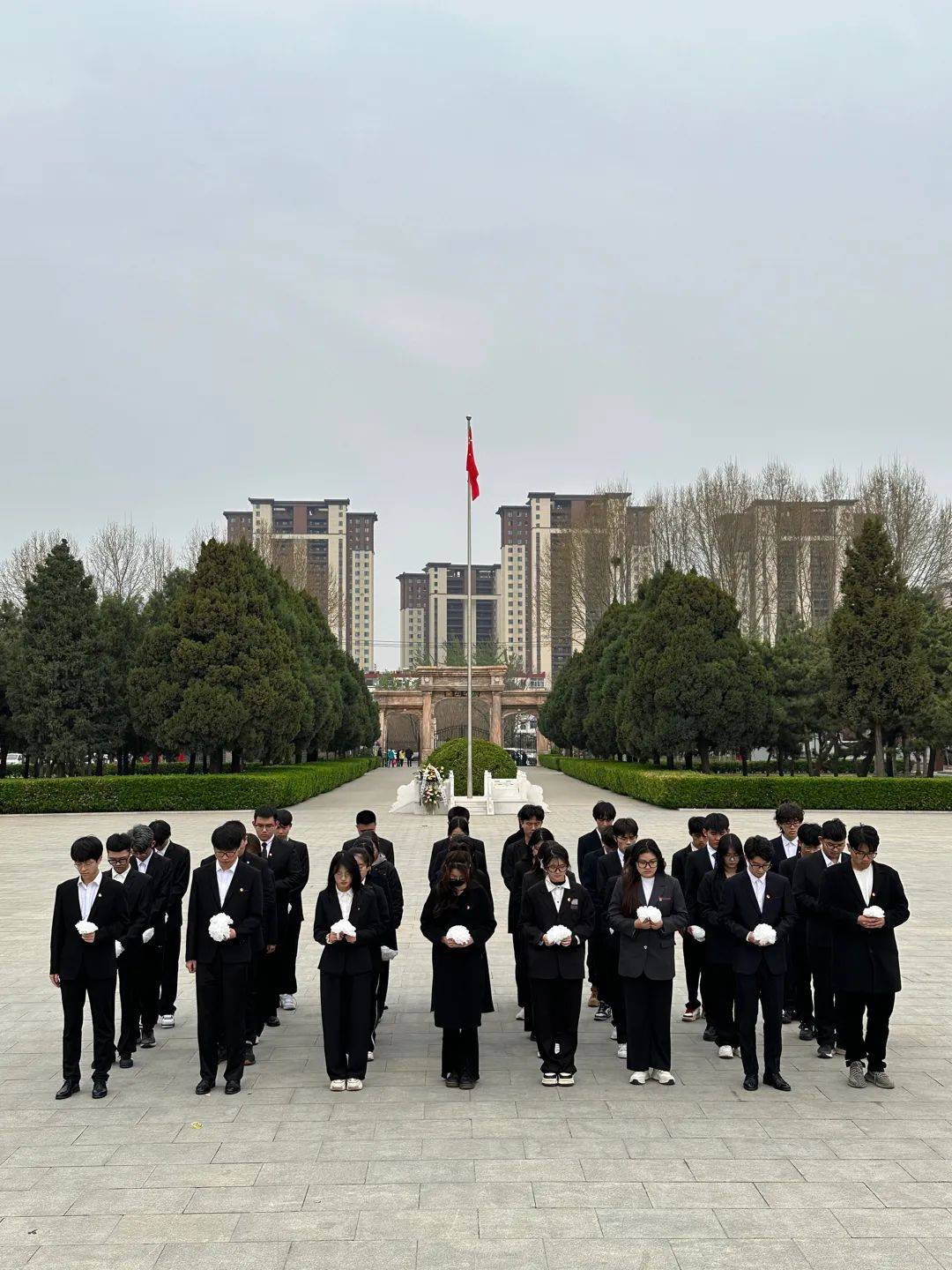 在英烈亭前全体人员神情肃穆共同奏唱国歌向国旗敬礼瞻仰纪念碑并