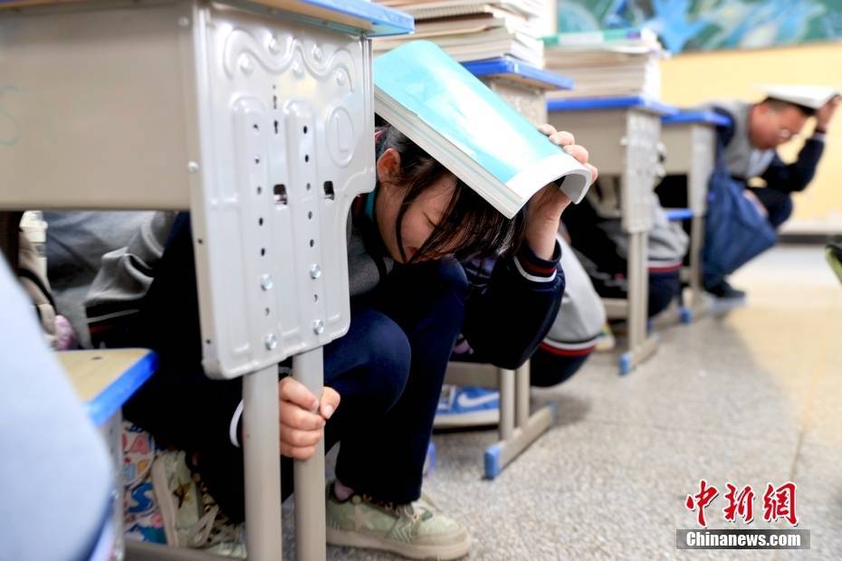 5月13日,在青海省西宁市海湖中学,演练启动后学生自行避险.