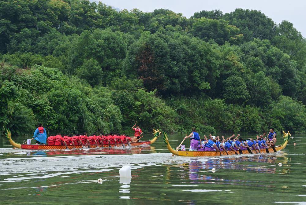 5月29日,在酉阳县龙潭镇,龙舟队在水面角逐.