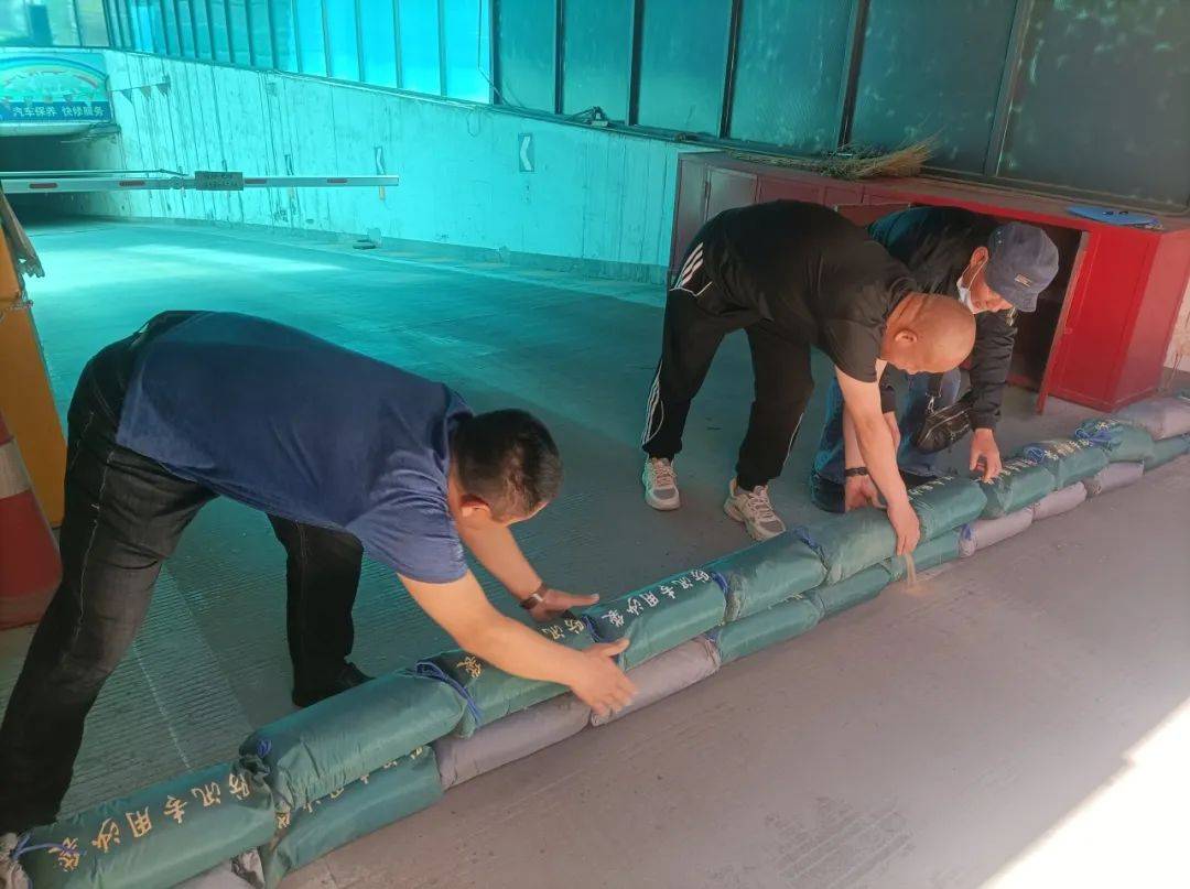 面对紧急情况大家立即在地下车库进出口码放防汛沙袋,同时迅速启动