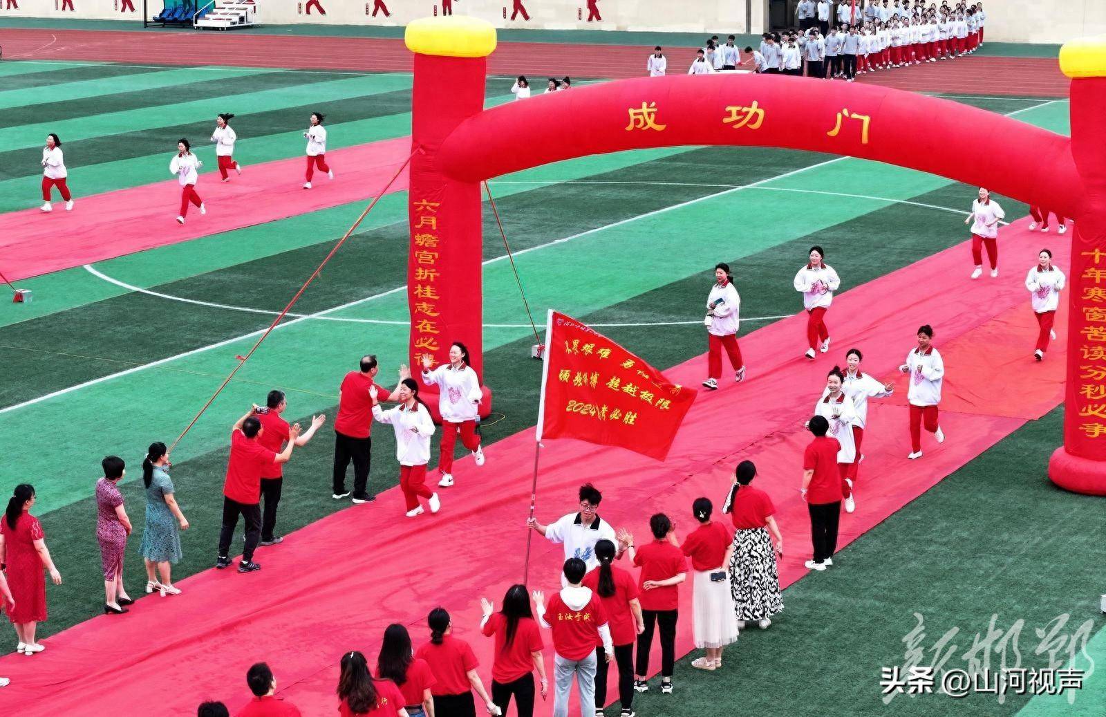 6月7日,河北省邯郸市峰峰第一中学的考生们跑过"成功门".