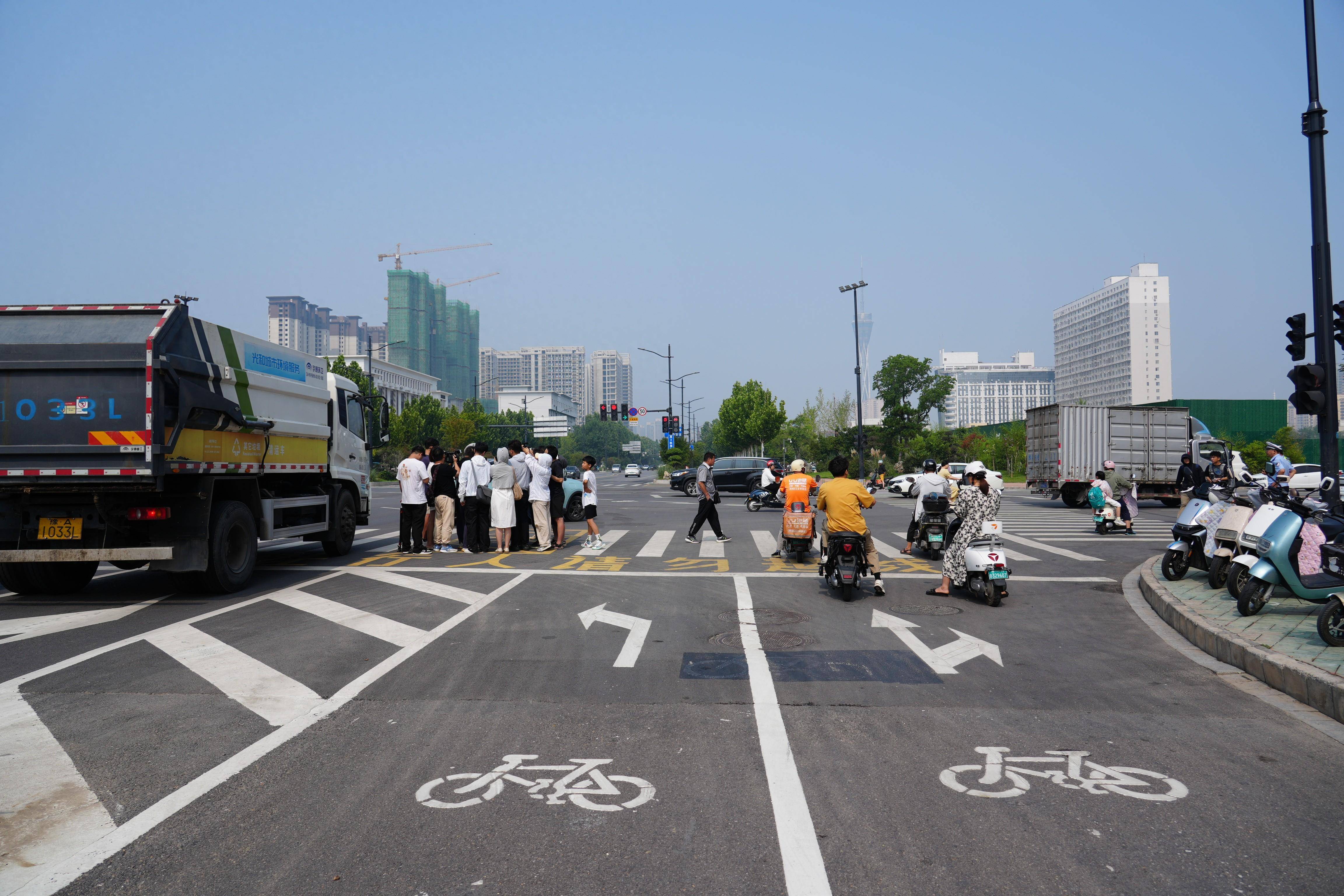 "7月11日,在郑州市航海路与第三大街交叉路口,骑电动车路过的美团外卖