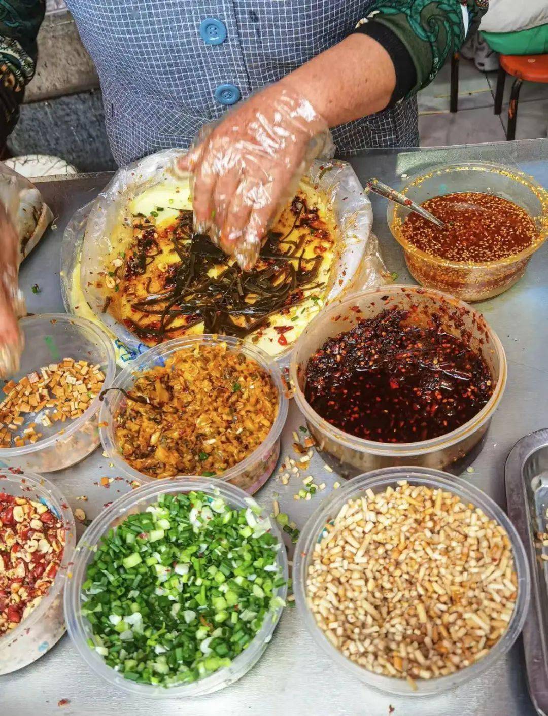 还有种手摊凉粉,就是在没切的米凉粉中间加满料,尤其是花生碎加的