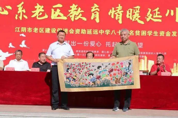 延川县延远中学校长刘涛向江阴市老促会赠送锦旗向贫困学生发放资助金