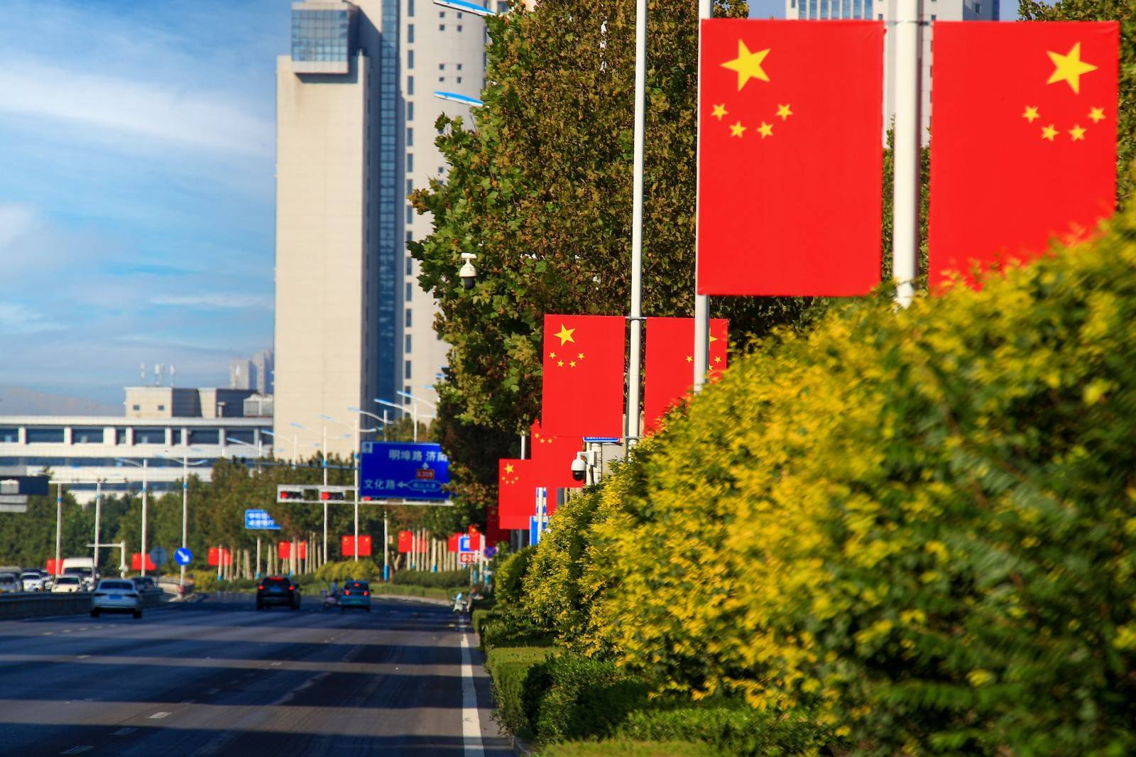   走上街头,蓝天白云,城市建筑与鲜艳的五星红旗交相辉映,过往