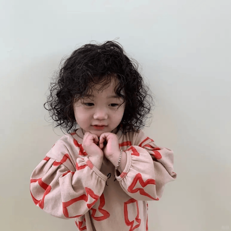 微微卷曲的发丝,像是俏皮的小精灵在舞动,为孩子增添了无尽的灵动与