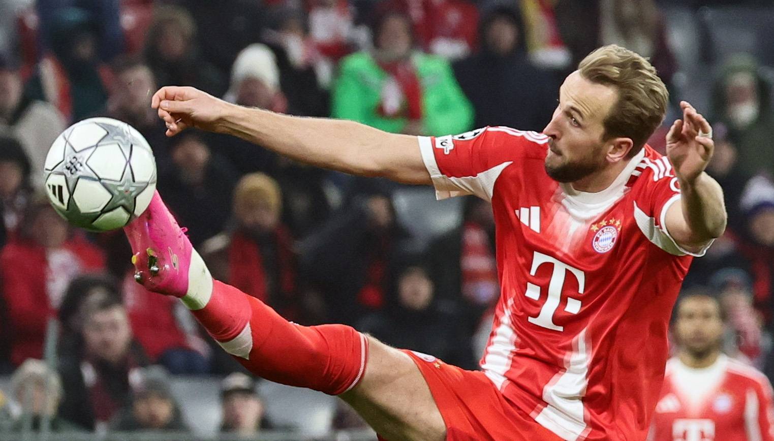 Harry Kane volleying the ball in a Bayern Munich home shirt during a Champions League match